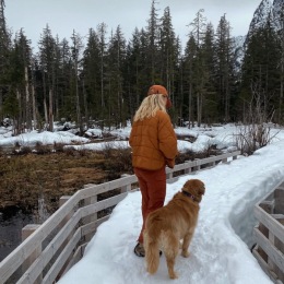 woman walking a dog in the snow
