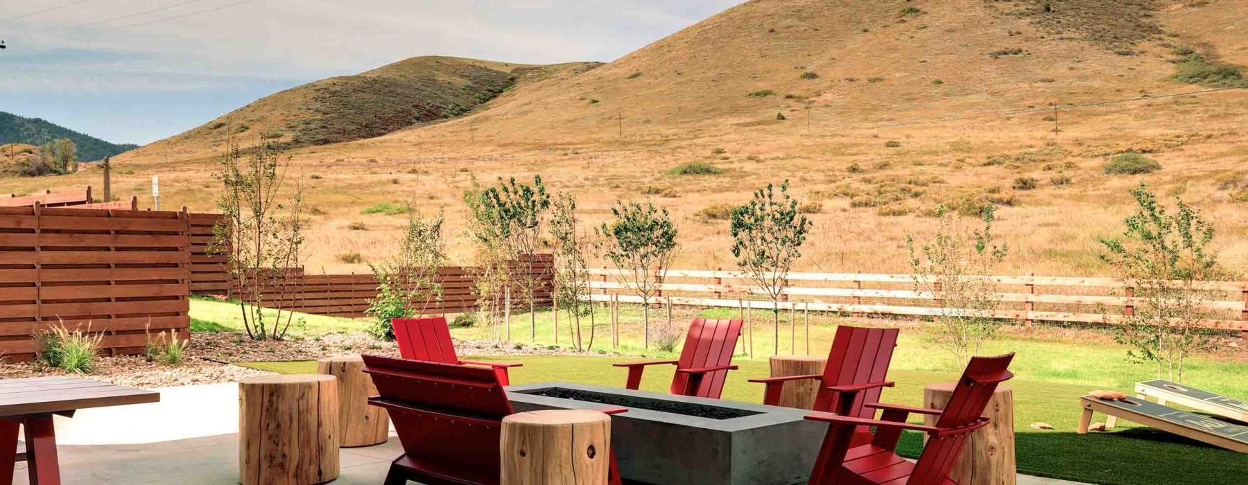 a group of red benches near a large hill